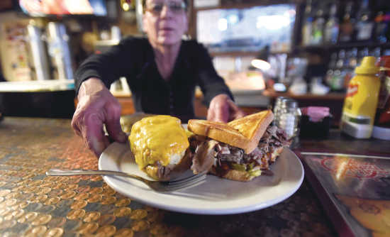 Worker placing a plate of food on table at the Pilot House restaurant located in Southeast Missouri