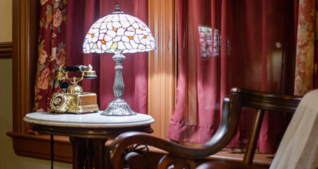 Side table with antique lamp and phone in the Mississippi Queen rental home located in Southeast Missouri